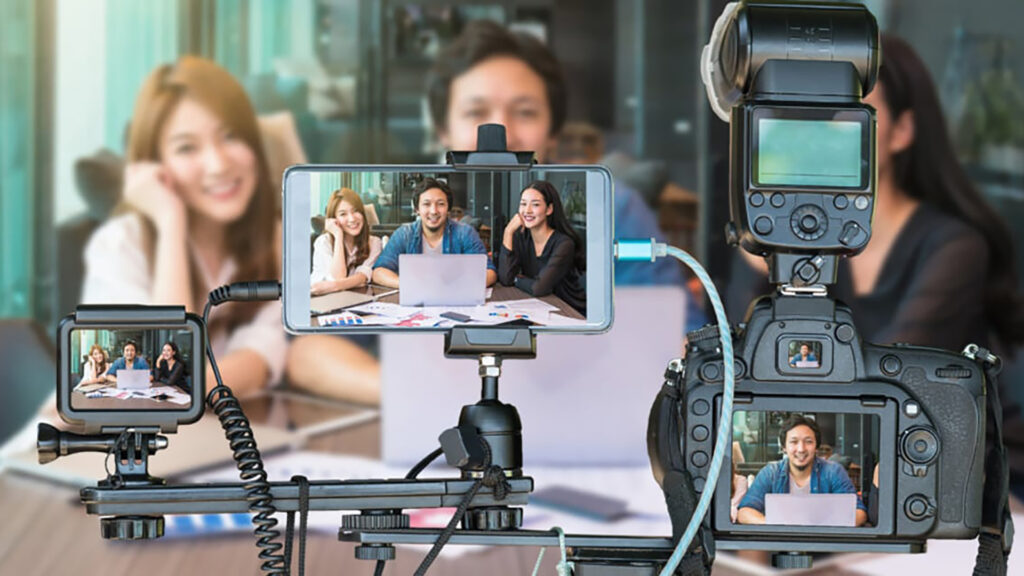 Group of people live streaming through a camera and mobile device