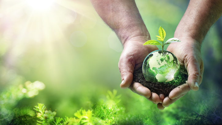 Graphic of a man holding planet Earth with a plant growing out of it