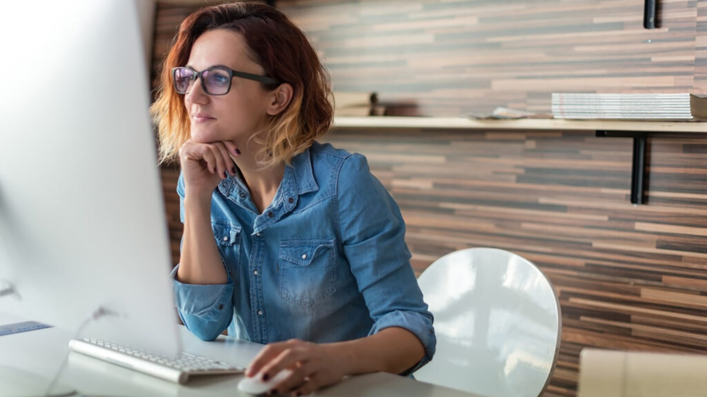 Woman working at her desktop smiling