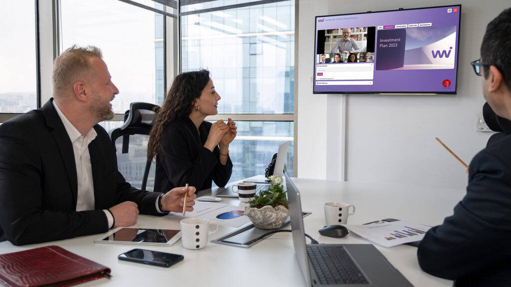 Small group of co-workers attending a virtual event at a conference table