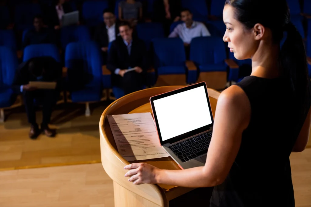 Female Business Executive Giving Speech at GlobalMeet Hybrid Event