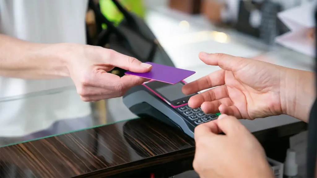 image of a person handing a credit card to a cashier