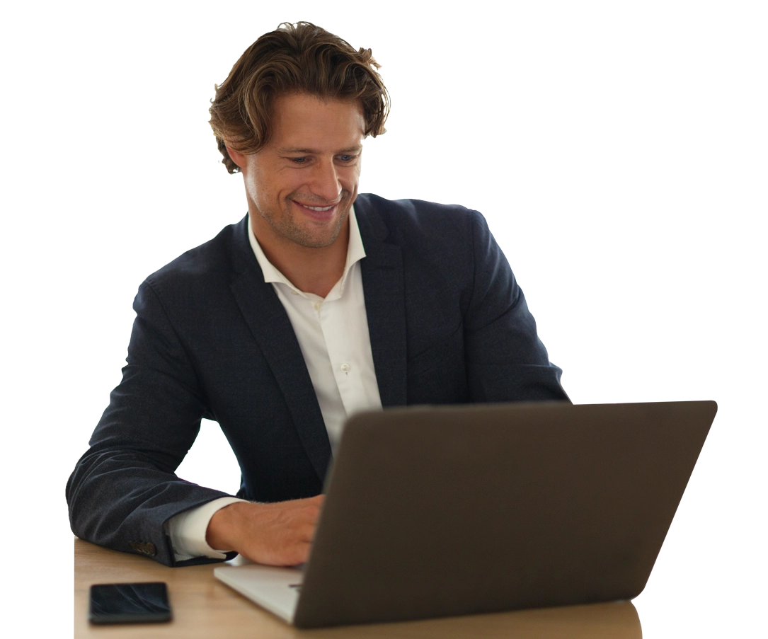 An image of a man in a suit sitting at a laptop