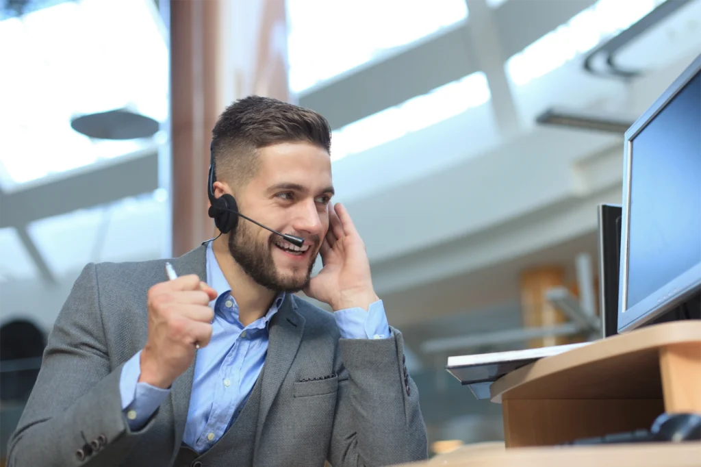 a smiling man in a suit wearing a headset. Representation of a GlobalMeet event producer