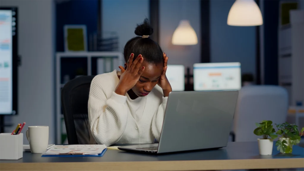 Woman stressed at her desk representation of cognitive overload